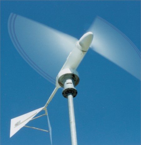 close up of small scale farm wind turbine turning with blue sky 