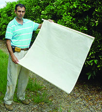 Figure 2. A Fuller’s rose weevil monitoring mat. A length of electrical conduit is placed into a sleeve on either end of the shade cloth mat to make it easier to place under the tree.