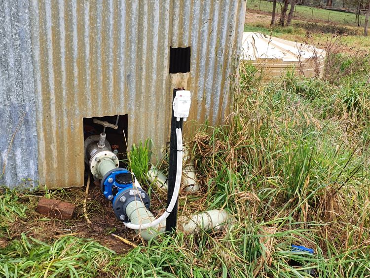 Irrigation flow sensor attached to irrigation line in an orchard