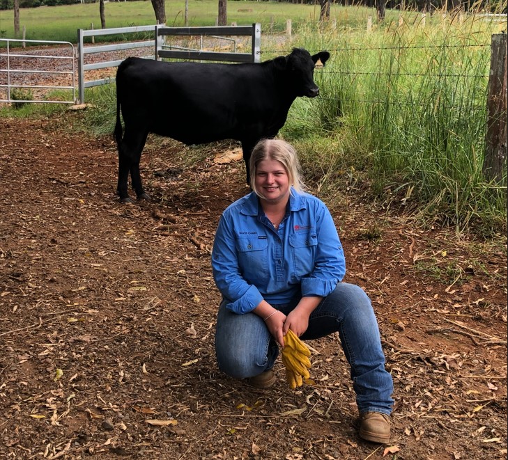 Northern Rivers resident Emma Somerville kneeling in front of an angus steer