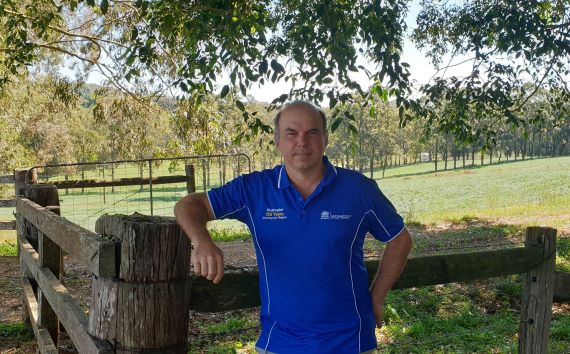 Lukas Van Zweiten in a blue shirt leans on a fence in a paddock