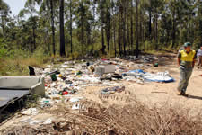 Community liaison forester David Wilson surveys a mound of decaying furnituredumped in Nambucca State Forest