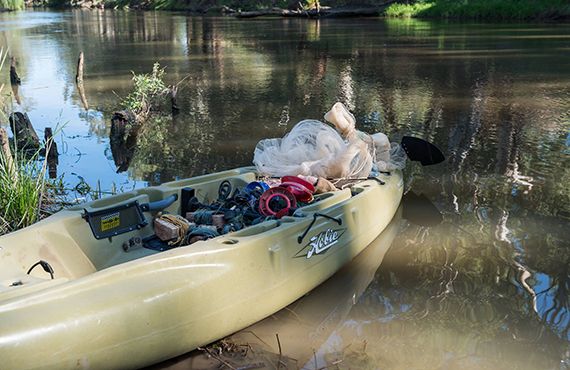 Paddle boat on the bank of the Lachlan River (NSW Central West) filled with seized fishing lines and cast nets