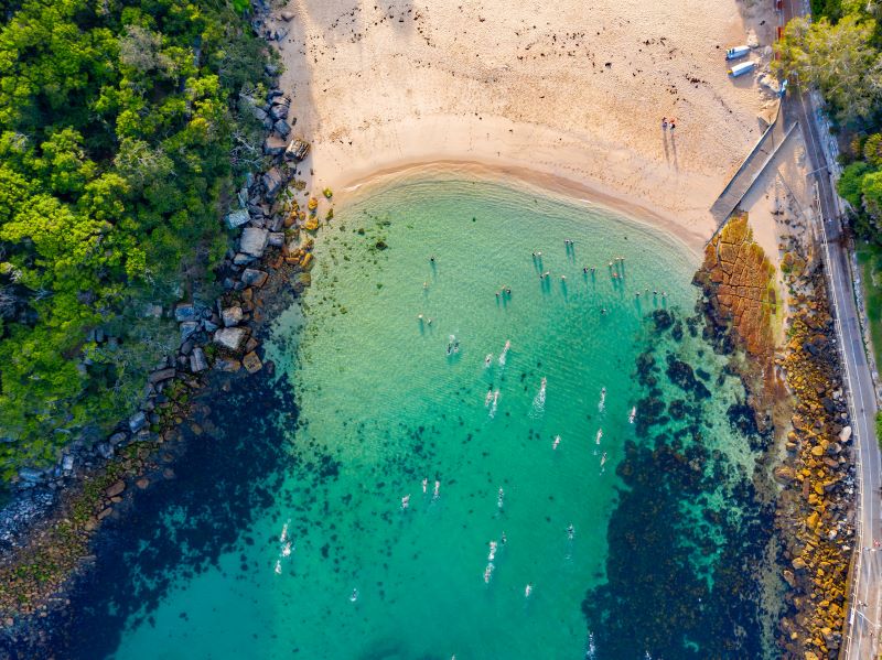 aerial view of cove with sandy beach and blue green water