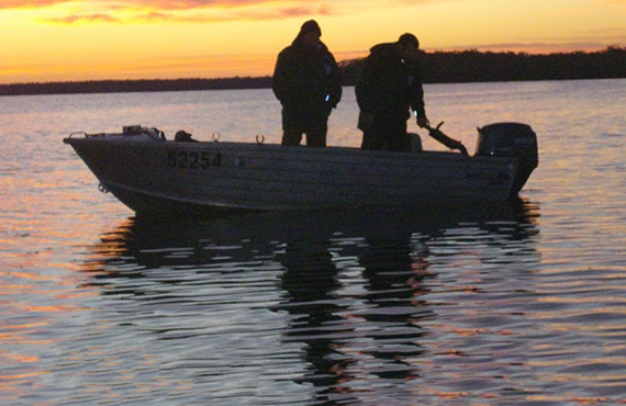 Fishermen in boat at dawn, Photo: Britt Anderson