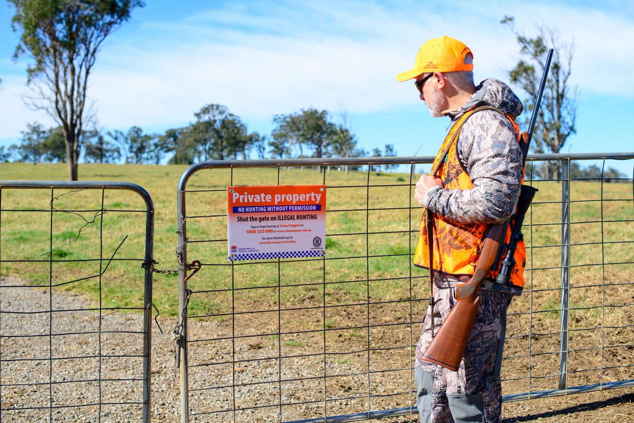 Hunter looking at private property sign on gate