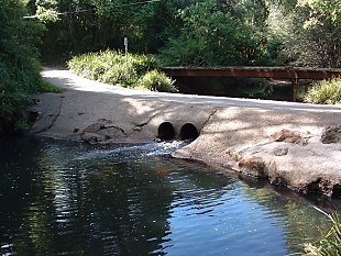 A creek flows through two pipes 