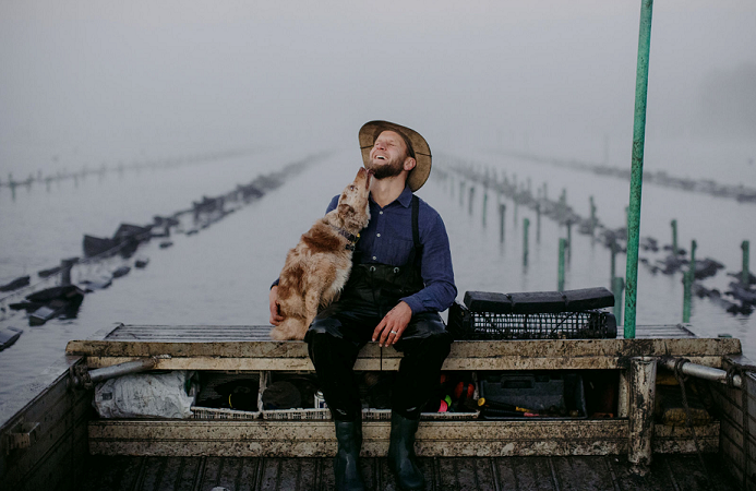 Jason Finlay with his dog at his oyster farm