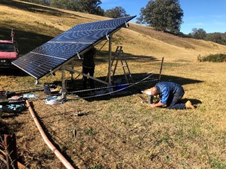 solar powered irrigation system being set up solar panels and equipment on farm field