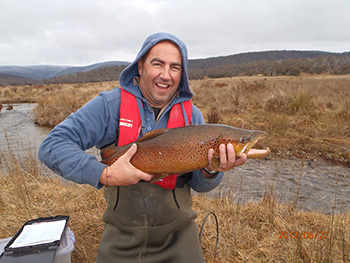 A photo of a fisherman holding a trout
